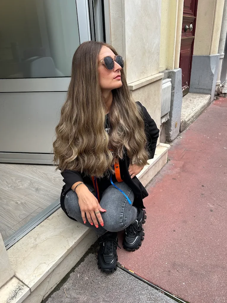 Cliente aux longs cheveux ondulés, perruque naturelle Dvora C Wigs, devant le salon de Levallois-Perret